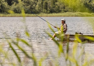 Man fiskar i lugn miljö från brygga vid sjön på Valle Camping i Skaraborg