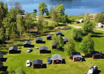 Flygfoto över stugor och campingområde vid sjön på Valle Camping